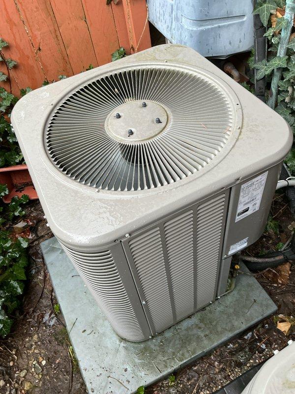 Completed comprehensive Gold AC Inspection on dual-zone residential cooling system including newer attic-mounted upstairs unit (2 years old) and older outdoor downstairs condenser unit. Performed full system diagnostics, refrigerant level verification, electrical component testing, and airflow measurements on both units. Outdoor condenser exhibited significant biological growth with moss and algae accumulation on fan cover, housing louvers, and upper surfaces due to extended exposure and deferred maintenance. Cleaned condenser coils, removed organic debris, treated biological growth, and restored proper airflow capacity. Inspected and cleaned condensate drain lines, verified thermostat calibration, tested capacitors and contactors, measured amp draw on compressor and fan motors, and confirmed proper cycling on both systems. All components operating within manufacturer specifications following maintenance procedures. Recommended ongoing seasonal maintenance to prevent future biological 