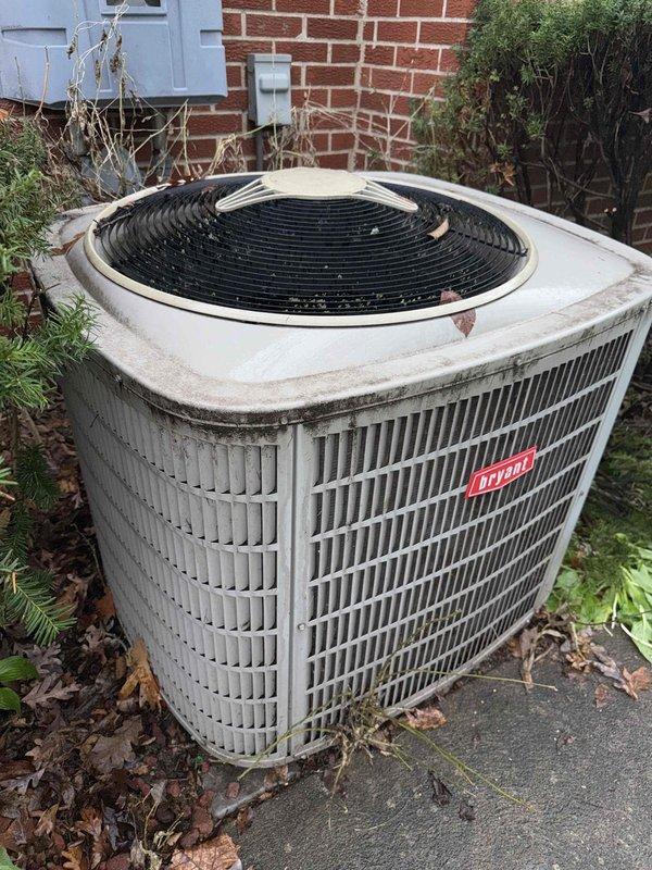 # No Cool Service Call - 25-Year-Old Bryant AC Unit

Responded to a no cooling complaint on a 25-year-old Bryant air conditioning system located on the side of the residence. Upon arrival, performed visual inspection of the outdoor condenser unit, which showed significant signs of age, weathering, and lack of maintenance. The unit exhibited heavy dirt accumulation, debris buildup around the base, and discoloration on cabinet panels.

Documented the overall condition of the equipment through photographs, noting the deteriorated state of the outdoor unit with dead leaves and organic matter surrounding the concrete pad. The condenser grille and cabinet showed weathering consistent with extended outdoor exposure and minimal preventive maintenance over its service life.

Given the advanced age of the system at 25 years—well beyond the typical 15-20 year lifespan of residential AC equipment—advised customer that the unit has exceeded its expected service life. Explained that parts availabili