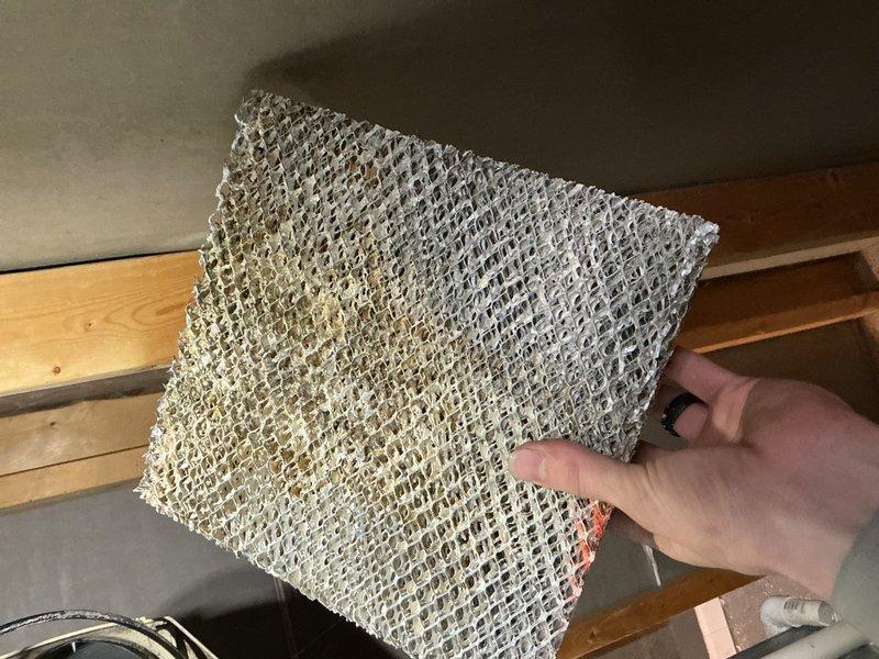 Responded to service call for 18-year-old furnace system located in basement with reported issue of broken water line feeding the humidifier. Upon inspection, identified failed water supply line connection to whole-house humidifier unit. Removed and replaced damaged water supply tubing and fittings to restore proper water flow to humidifier system. Inspected humidifier evaporator pad and found significant mineral buildup and discoloration indicating reduced efficiency. Replaced heavily soiled evaporator pad with new filter media to ensure optimal humidification performance. Checked condensate pump assembly and associated drainage components for proper operation. Verified all connections secure and tested system operation. Humidifier now receiving adequate water supply and operating within normal parameters.