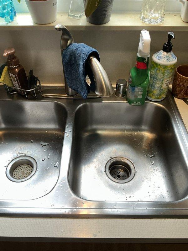Installed new Kenmore garbage disposal unit under kitchen sink in 67-year-old residential home. Removed existing disposal, mounted new unit to sink drain flange, connected white PVC P-trap drainage system, and completed electrical wiring connections. Tested unit for proper operation and verified all plumbing connections were secure with no leaks.