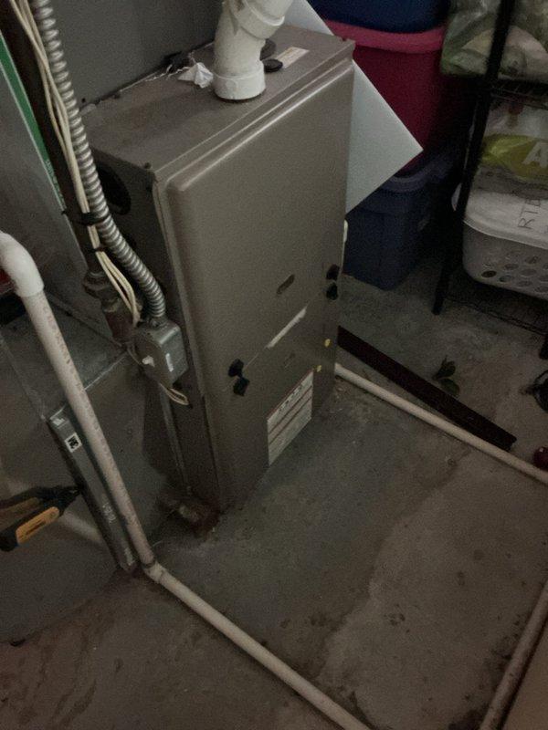 Responded to customer complaint of insufficient cooling from 3-year-old air conditioning system. Performed visual inspection of indoor evaporator coil located in basement and outdoor condensing unit. Documented equipment condition with photographs showing furnace/air handler assembly with connected refrigerant lines and outdoor condenser unit positioned adjacent to building exterior. System components appeared operational with no obvious signs of mechanical failure or refrigerant leakage at time of inspection.