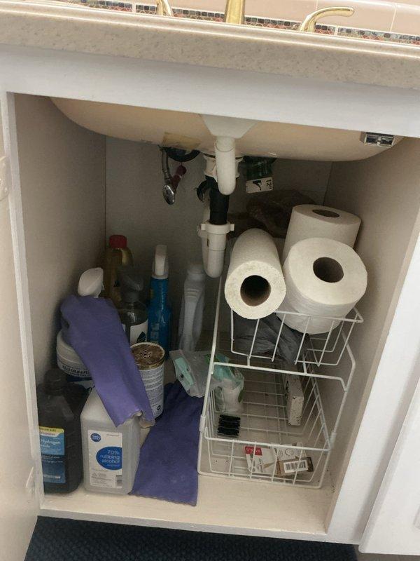 Responded to water leak complaint originating from second floor and manifesting through garage ceiling. Investigated plumbing fixtures in second floor bathroom and utility areas. Inspected under-sink plumbing assembly including P-trap, drain connections, and supply line fittings for signs of active leakage or moisture accumulation. Documented conditions with photographic evidence for customer records.
