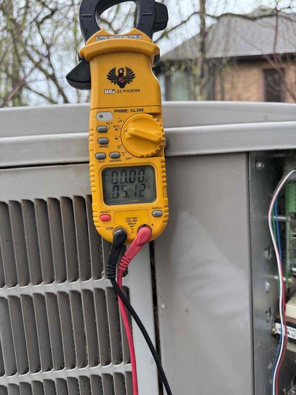 Responded to service call for 15-year-old air conditioning unit experiencing short cycling, where system would turn on and immediately shut off. Performed diagnostic evaluation of outdoor condenser unit located behind residence. Used digital clamp meter to test electrical parameters and identified failed run capacitor rated at 40µF on the Genteq condenser fan motor. Replaced defective capacitor, verified proper voltage supply at 370VAC, and confirmed all electrical connections were secure. Tested system operation and confirmed unit now runs through complete cooling cycles without interruption.