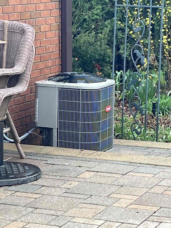 Performed comprehensive Gold AC inspection and tune-up on a 10-year-old residential air conditioning system located in the backyard. Unit is a cylindrical condenser installed on concrete paver patio with proper clearance and access. Conducted complete system diagnostics using R410A refrigerant testing equipment, measuring return dry bulb temperature at 65.4°F, return wet bulb at 55.2°F, supply wet bulb at 43.7°F, and supply dry bulb at 46.3°F, indicating proper temperature split and system performance. All measurements fell within acceptable operating parameters for optimal cooling efficiency. Unit exterior housing and protective grille cover inspected and found in good condition with no visible damage or deterioration. System operating normally with no issues identified during inspection.