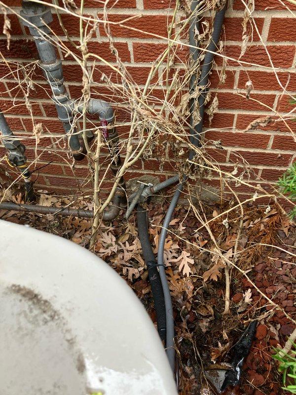 Provided estimate for complete air conditioning system replacement for 25-year-old unit experiencing insufficient cooling due to failed outdoor fan motor capacitor and restricted airflow from vegetation growth into condenser coil. Documented existing thermostat settings and outdoor unit location on side of house with significant landscaping obstruction requiring clearance for proper system operation.