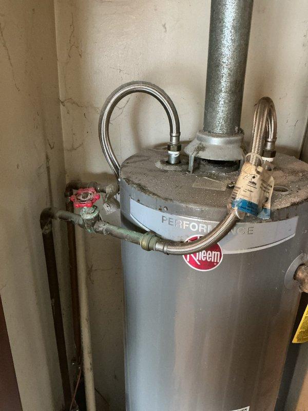 Responded to service call for 12-year-old Rheem Performance 40-gallon natural gas water heater located in utility room with reported venting issues. Upon inspection, diagnosed improper venting preventing safe exhaust of combustion gases. Completed installation of new tanked water heater system, including proper venting configuration to ensure adequate draft and combustion air flow. Connected supply lines with flexible braided hoses, installed temperature and pressure relief valve, and verified all gas connections for leak-free operation. System tested and operational upon completion.