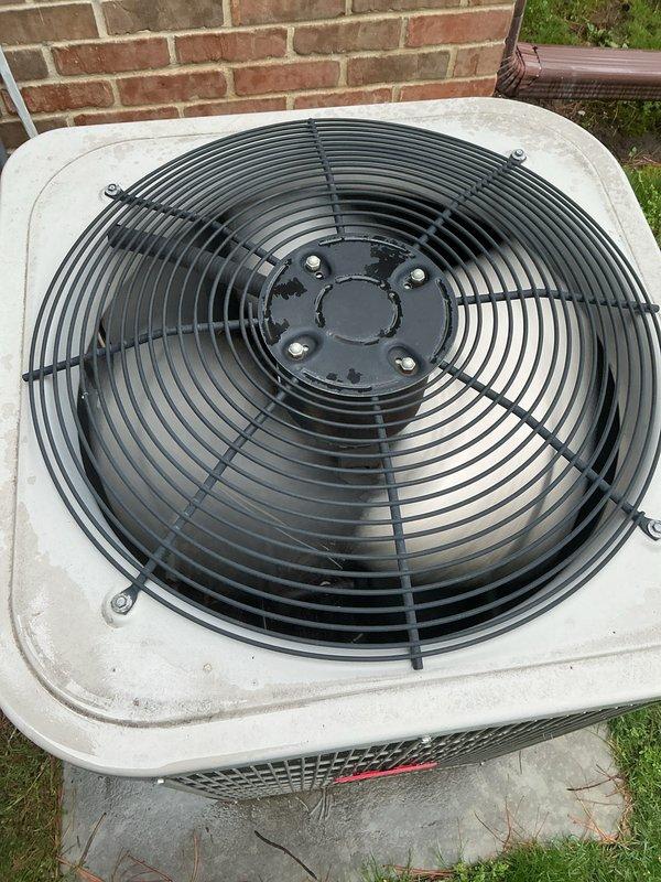 Completed comprehensive Gold AC Inspection and seasonal maintenance on two residential air conditioning systems (4-year-old and 6-year-old units) located at exterior and basement positions. Performed full system diagnostics including refrigerant level verification, electrical component testing, condenser coil cleaning, air filter inspection and replacement, thermostat calibration, and condensate drain line clearing. Inspected outdoor condenser unit with top-mounted fan assembly, verified proper operation of fan motor and protective wire guard, examined housing integrity and coil fins for damage or debris accumulation, and confirmed adequate airflow through perforated side grilles. Tested compressor amperage draw and capacitor performance to ensure optimal efficiency. Evaluated both systems for pre-summer readiness, finding units operating within manufacturer specifications with no immediate repairs required. Documented equipment condition through photographic records showing clean exte