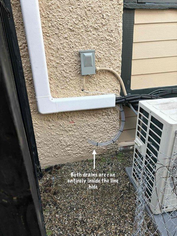 Completed warranty return visit to reroute exterior condensate drain lines per customer request. Successfully relocated both primary and secondary condensate drains to run entirely concealed within the white PVC line hide chase from the air handler to the outdoor condensing unit, eliminating exposed drain lines on the building exterior. All drain lines properly pitched and secured, with condensing unit positioned on gravel pad and electrical disconnects properly mounted to exterior wall.