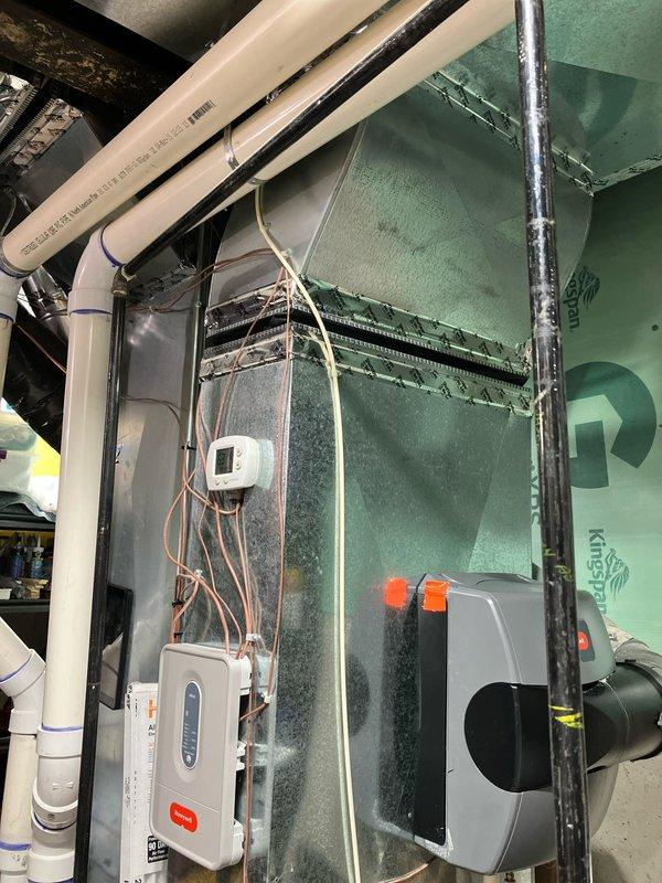 Conducted estimate appointment for replacement of 11-year-old air conditioning system with outdoor unit located at side of house and indoor components in basement. Assessed existing HVAC equipment including green sheet metal ductwork, electrical controls, and air handler with motor assembly in mechanical room. Evaluated current thermostat operation displaying cooling setpoint of 74 degrees and documented system configuration for replacement proposal.