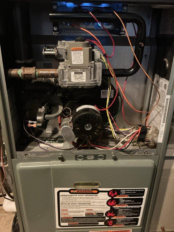 Completed comprehensive tune-up on residential gas furnace and air conditioning system. Performed full system inspection with access panel removed, verifying gas valve operation, burner ignition sequence, and flame characteristics showing proper blue combustion. Inspected blower motor assembly, electrical connections, and all safety controls for proper operation. Evaluated outdoor condensing unit including fan motor operation, noting surface corrosion on fan grille and motor hub area consistent with normal weathering. Confirmed both heating and cooling systems operational and functioning within manufacturer specifications.