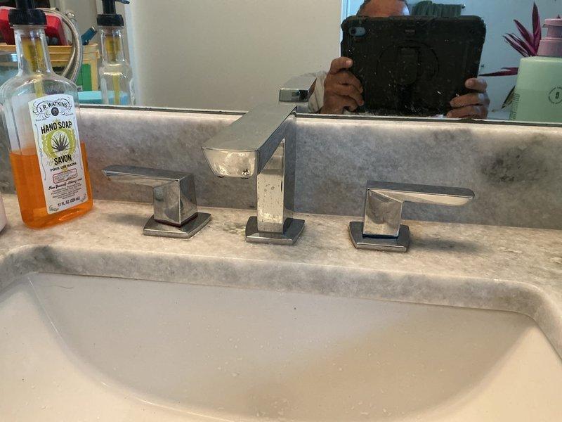 Responded to service call for clogged faucet with suspected faulty regulator. Upon inspection, diagnosed issue with water supply lines causing restricted flow to the three-piece widespread bathroom faucet. Replaced both deteriorated flexible supply lines with new braided stainless steel hoses, ensuring proper connections at shutoff valves and faucet tailpieces. Tested hot and cold water flow through both handles, verified full functionality, and confirmed no leaks at connection points.