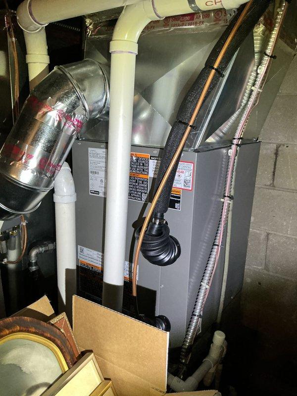 Performed comprehensive Gold-level AC inspection and system startup on 6-month-old HVAC system with air handler located in basement. Conducted thorough multi-point inspection of air handler unit, verified proper operation of all electrical components, and confirmed refrigerant lines with black insulation were properly secured and routed. Inspected white PVC condensate drain lines for proper pitch and drainage, examined metallic ductwork connections at plenum for air-tight seals, and verified all safety labels and manufacturer specifications were visible and intact. Checked outdoor condenser unit and confirmed surrounding area was clear of debris and obstructions for proper airflow. Tested system operation under current ambient conditions, verified temperature differential across evaporator coil, and confirmed equipment was cycling properly. All components functioning as designed with no deficiencies noted. System startup completed successfully and unit left in proper working order.