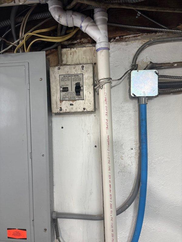Completed installation of 50-gallon electric tank water heater with coordinated electrical disconnect by licensed electrician. Installed new unit with PEX supply lines, braided stainless steel flex connectors, and proper venting components including Dura-Vent power vent system. All plumbing connections secured with brass fittings and compression connections per code requirements, with work performed under permit referenced on job #1310563 for mechanical hot water heater reconnection.