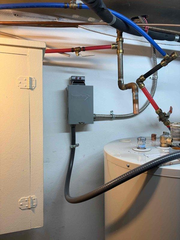 Completed installation of 50-gallon electric tank water heater with coordinated electrical disconnect by licensed electrician. Installed new unit with PEX supply lines, braided stainless steel flex connectors, and proper venting components including Dura-Vent power vent system. All plumbing connections secured with brass fittings and compression connections per code requirements, with work performed under permit referenced on job #1310563 for mechanical hot water heater reconnection.