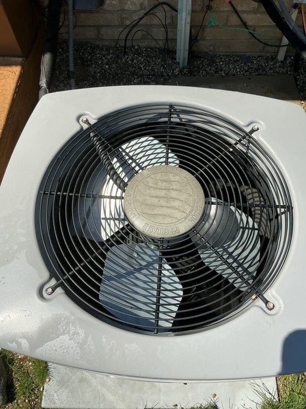 Completed Gold AC inspection on residential single-unit air conditioning system with equipment age exceeding 10 years. Inspected outdoor condensing unit with operational fan assembly and protective grille, verifying proper function and clearance from debris. Air handler/coil located in basement confirmed. Documented significant rust corrosion present throughout electrical disconnect box enclosure, including deterioration around interior panel edges, cable entry points, and mounting surfaces indicating prolonged moisture exposure requiring attention. Unit operational at time of inspection with weather conditions suitable for accurate assessment.
