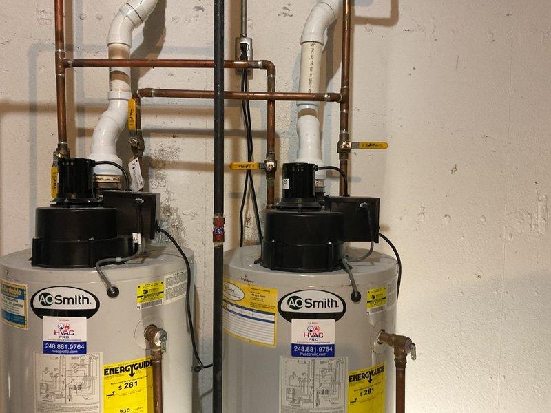 Completed installation of dual 50-gallon AO Smith power vent water heaters in basement utility room. Established all hot and cold water supply connections using copper piping with proper shut-off valves, installed PVC power vent exhaust systems for both units, and completed electrical connections to code. All plumbing connections were tested for leaks, units were energized and verified operational, and system was left fully functional with proper venting configuration.