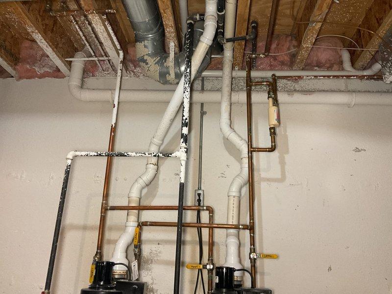 Completed installation of dual 50-gallon AO Smith power vent water heaters in basement utility room. Established all hot and cold water supply connections using copper piping with proper shut-off valves, installed PVC power vent exhaust systems for both units, and completed electrical connections to code. All plumbing connections were tested for leaks, units were energized and verified operational, and system was left fully functional with proper venting configuration.