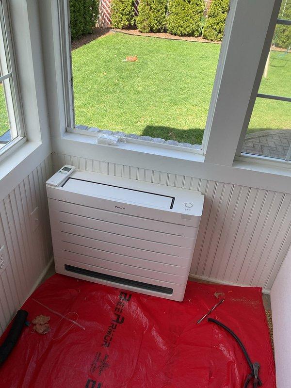 Completed installation of Daikin mini-split system in interior room with outdoor condenser located in rear yard. Ran refrigerant lines with linehide concealment, installed new dedicated electrical circuit at main panel, and positioned indoor wall-mounted unit beneath window on wainscoting. All mechanical and electrical permits were obtained prior to installation, system tested and operational upon completion.