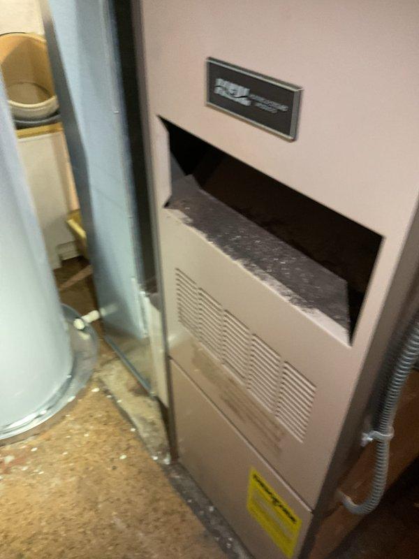 Completed comprehensive tune-up inspection on 10+ year old HVAC system located in basement. Performed thorough examination of furnace, humidifier, thermostat, and hot water tank as part of city certification inspection. Documented heavily soiled air filter showing significant dirt accumulation and discoloration, indicating need for immediate replacement to maintain proper airflow and system efficiency.