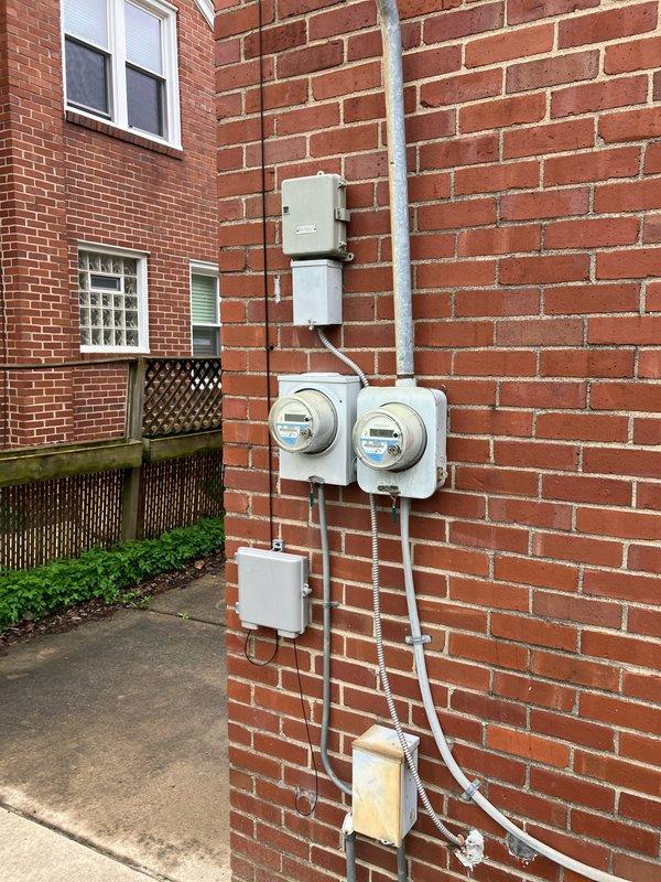 Completed comprehensive HVAC estimate for full system replacement on multi-unit residential building. System assessment revealed ZR-22 refrigerant system was completely empty, indicating major leak or component failure requiring full system replacement rather than repair. Documented existing exterior utility infrastructure including electrical metering and conduit configuration for proper system sizing and electrical load calculations, and photographed current Honeywell programmable thermostat for replacement specifications and compatibility requirements.
