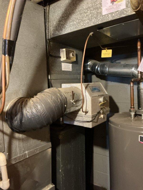 Performed comprehensive inspection, deep cleaning, and pad replacement on aging furnace-mounted humidifier unit located in basement storage room. Removed accumulated mineral deposits and biological growth from water panel assembly, cleaned distribution tray and reservoir, and installed new evaporator pad to restore proper humidity output and prevent mold development. Verified water supply line flow, checked drain functionality, and confirmed unit operation following service completion.