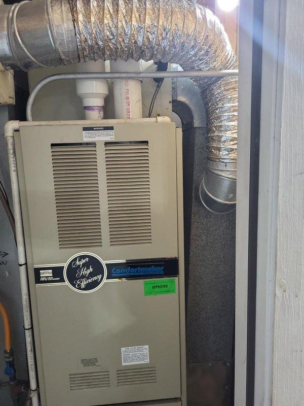 Conducted remeasure appointment for HVAC system replacement at residential property. Documented existing Comfortmaker super high-efficiency furnace installation in interior mechanical closet and outdoor cylindrical condenser unit positioned on exterior side yard against brick foundation. Captured measurements and photographic documentation of current equipment configuration, ductwork routing, PVC condensate lines, and available installation space to finalize replacement system specifications and prepare accurate estimate.