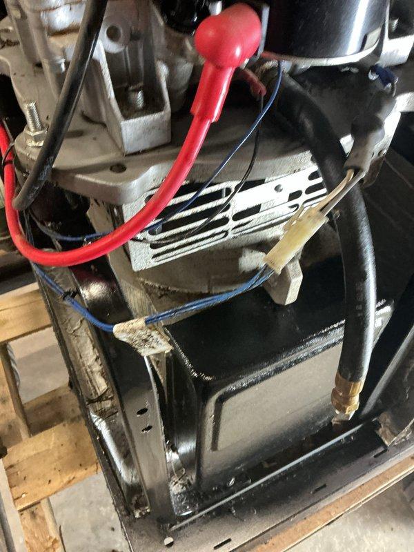 # Generator Repair

Responded to service call for generator system requiring repair. Upon inspection, identified issues with the engine assembly and associated components requiring attention. Performed comprehensive diagnostic assessment of the POWER CODE branded engine unit, examining electrical connections, fuel system components, and cooling system integrity.

Addressed mechanical issues within the engine assembly, including inspection and service of the carburetor/fuel delivery system visible in the lower portion of the unit. Verified proper operation of air-cooled engine components, ensuring adequate heat dissipation through the finned housing design. Examined and tested all electrical wiring connections, including orange and red insulated wires connected to various engine points, confirming proper voltage and continuity throughout the system.

Inspected and serviced HVAC/refrigeration components integrated with the generator system, including the black metallic compressor housing