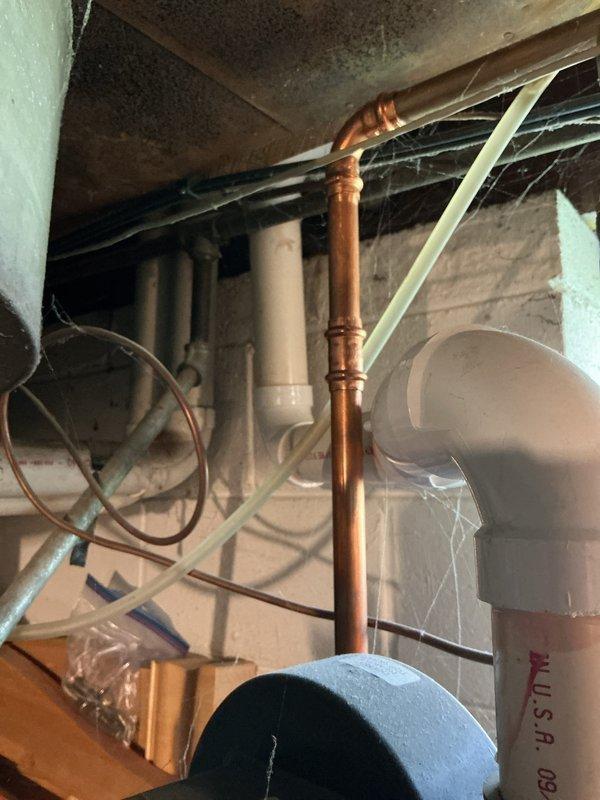 Conducted on-site assessment of existing HVAC system in residential basement mechanical room to provide replacement estimate. Evaluated current furnace unit with white cabinet base and galvanized metal plenum, noting configuration of existing ductwork connections including flexible black duct at upper plenum. Documented electrical service routing and conduit placement for equipment replacement planning. Assessed available clearances around existing equipment, including proximity to water heater and surrounding plumbing infrastructure. Examined overhead ductwork, copper piping, and PVC drain lines to determine any modifications needed for new equipment installation. Photographed current system layout and mechanical room conditions to support accurate equipment sizing and replacement proposal for both furnace and air conditioning components.