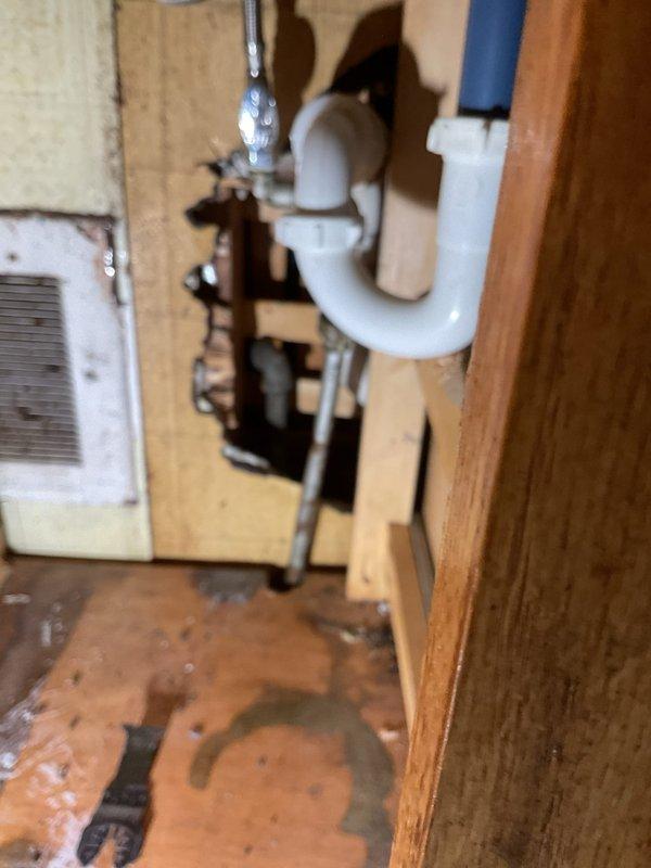 Responded to a plumbing service call to address aging galvanized water supply lines and under-sink drainage concerns. Inspected attic/crawl space plumbing infrastructure where corroded galvanized pipes, deteriorated shut-off valves, and oxidized fittings were identified as potential failure points requiring monitoring or replacement. Examined under-sink cabinet area where PVC drain assembly and P-trap were assessed for proper function, noting previous water staining on cabinet floor indicating past leak history. Documented existing plumbing conditions with photographic evidence for service records and provided recommendations for future maintenance to prevent water damage.