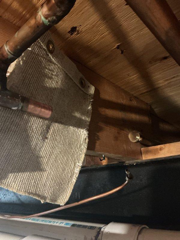 Responded to a slow leak in the basement of a 40-year-old residential property. Upon inspection of the crawl space, located the source of the leak in the copper supply line system running through the floor joists. The aging copper piping showed signs of corrosion and patina consistent with the home's age. Identified a compromised joint connection that had been slowly dripping for approximately 24 hours. Repaired the affected section by replacing the faulty fitting and securing all connections. Verified the integrity of surrounding copper pipes and PVC drainage lines. Tested the system for proper water pressure and confirmed no additional leaks were present. Documented the existing plumbing infrastructure with photographs for maintenance records. The repair was completed successfully with no further water intrusion detected.