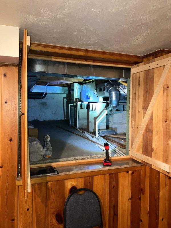 Provided estimate for complete furnace replacement after diagnosing failed inducer motor on 25-year-old unit located in basement crawlspace. Due to age of equipment and repair costs exceeding replacement threshold, recommended full system replacement rather than component repair. Documented existing electrical panel configuration and accessed mechanical space through cabinet entry point to assess installation requirements for new equipment.