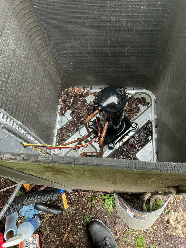 Returned to property to perform comprehensive leak search on 2-year-old outdoor air conditioning unit experiencing no cooling condition. Utilized electronic leak detector and nitrogen pressure testing with flame torch to identify refrigerant leak points in system. Inspected condenser unit, refrigerant line connections, and compressor assembly for potential leak sources. Noted significant debris accumulation in drain pan and surrounding outdoor unit area that could impact system performance. Documented equipment condition and leak search findings with photographs for service records.