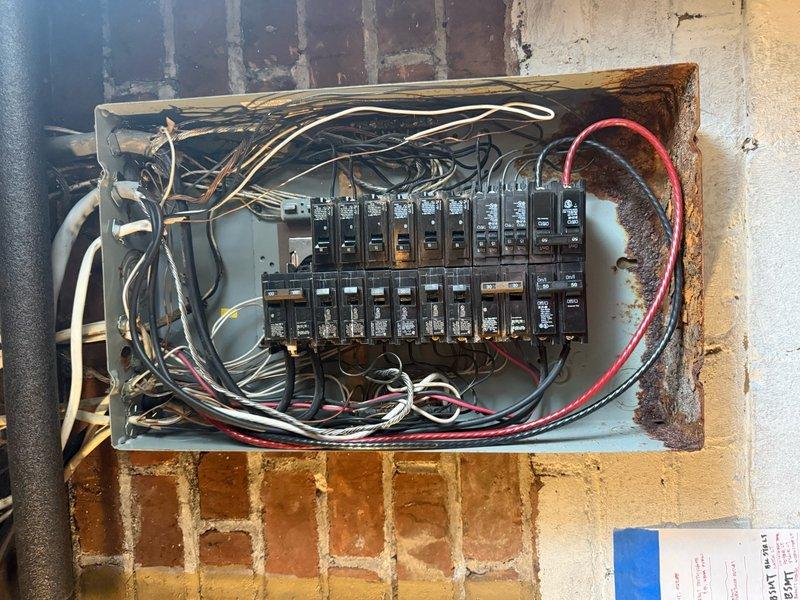 Responded to service call for rainwater intrusion into main electrical panel from meter location. Upon inspection, found significant rust and corrosion on panel enclosure exterior and mounting frame, confirming moisture exposure issues. Assessed all circuit breakers and internal wiring connections for water damage and safety concerns. Documented existing panel condition showing weathering on exterior metal housing while verifying all circuits remained operational. Provided recommendations for proper weatherproofing and sealing of meter-to-panel connection point to prevent future water infiltration and potential electrical hazards.