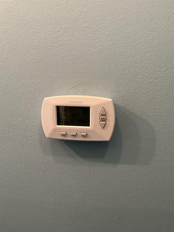 Completed Gold AC Inspection on residential air conditioning system with air handler located in basement. Performed comprehensive system evaluation including thermostat operation check, electrical connections inspection, and outdoor condenser unit assessment. Observed debris and nesting material accumulation around capacitor and wiring connections at outdoor unit, which was documented photographically. Verified thermostat functionality and system controls operating properly. Inspected electrical components including capacitor, contactor, and associated wiring connections showing normal age-related weathering. Noted organic debris buildup requiring attention to prevent potential electrical issues and maintain optimal airflow around condenser components.