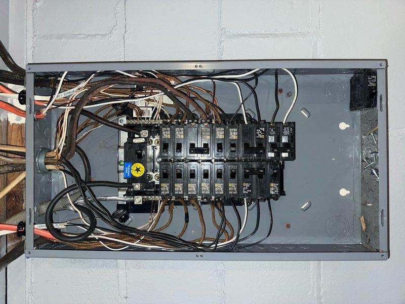 Performed comprehensive whole home electrical inspection following reports of cut ground wire and multiple electrical deficiencies in recently renovated property. Conducted thorough evaluation of main electrical panel, identifying disorganized wiring, improper wire management, and potential code violations including questionable wire connections with aftermarket connectors. Inspected exterior electrical fixtures and service entrance components, documenting conditions of outdoor lighting fixtures and service conductors mounted to building exterior. Photographed panel interior showing circuit breaker arrangement, bus bar configuration, and wire routing for documentation and future reference. Assessment revealed multiple areas requiring attention consistent with substandard installation practices, providing homeowner with detailed findings to address safety concerns and bring electrical system into compliance with current standards.