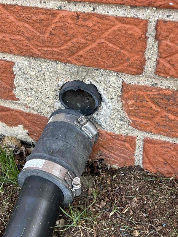 Completed comprehensive Gold AC inspection on 10+ year old residential air conditioning system with air handler/coil located in basement. Performed thorough multi-point inspection including examination of condensate drain line at exterior foundation, verified proper installation of flexible drainage hose with secure metal clamp connections at brick wall penetration. Inspected electrical components and terminal connections within system, confirmed all wiring terminations secure on terminal strip with proper grounding connections in place. Unit currently operational with no immediate service needs identified. All system components photographed and documented for maintenance records.