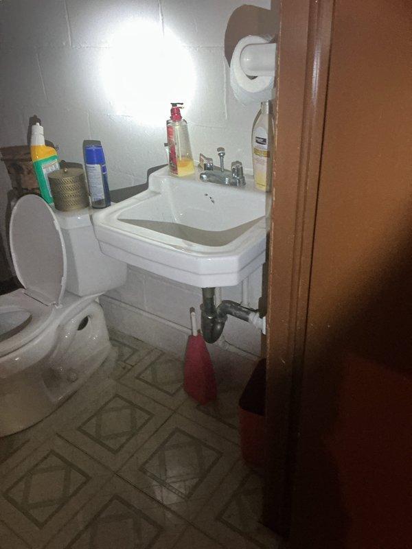 Responded to low water pressure complaint in kitchen hot water faucet and complete loss of water flow to outdoor/backyard faucet in 1950s-era home. Investigated plumbing system throughout property including main water shutoff valve location in basement. Inspected interior fixtures, supply lines, and outdoor hose bibs to diagnose pressure loss issues that had persisted since previous summer. Documented existing plumbing conditions and fixture configurations for service records.