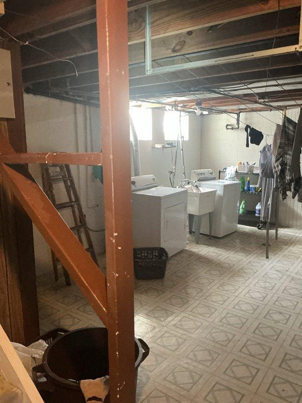 Responded to low water pressure complaint in kitchen hot water faucet and complete loss of water flow to outdoor/backyard faucet in 1950s-era home. Investigated plumbing system throughout property including main water shutoff valve location in basement. Inspected interior fixtures, supply lines, and outdoor hose bibs to diagnose pressure loss issues that had persisted since previous summer. Documented existing plumbing conditions and fixture configurations for service records.