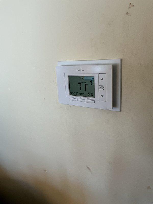 Completed comprehensive Gold AC inspection on 9-year-old residential air conditioning system with air handler located in basement. Verified system operational status, inspected Sensi programmable thermostat displaying 71°F, and examined furnace/air handler unit with integrated Aprilaire humidifier system including all associated copper tubing, brass fittings, and PVC drainage connections. All components found functioning properly with no service issues identified during inspection.