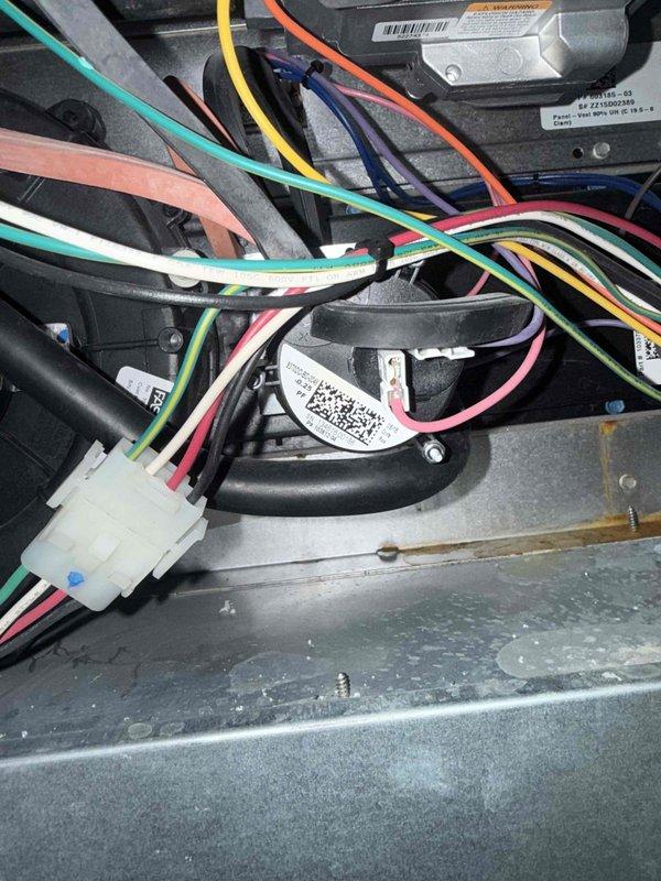 Responded to no heat call for 10+ year old furnace and AC system located in upstairs closet. Upon arrival, confirmed both units were completely non-operational with no power to system. Performed diagnostic inspection of furnace control board, wiring connections, and safety switches. Identified failed pressure switch preventing furnace ignition sequence from initiating. Inspected pressure switch tubing for blockages and verified proper connections. Documented internal wiring configuration and component layout showing multi-pin connector housing, control module, and safety devices. Pressure switch has been ordered and is available for pickup under PO: 1308894-001 for installation to restore system operation.