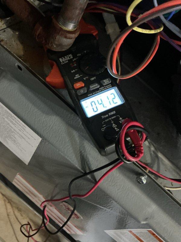 Completed comprehensive Gold AC inspection and tune-up on Daikin air conditioning system as part of plan membership benefits. Performed electrical diagnostics using digital multimeter to verify proper voltage and amperage readings at air handler unit, confirming system operating within manufacturer specifications at 4.12 measurement reading. Inspected indoor air handler cabinet, ductwork connections, and refrigerant line set for proper installation and integrity. Evaluated outdoor condensing unit including manufacturer label verification, electrical connections, and PVC condensate drain line routing. Noted outdoor unit showing age-appropriate weathering with minor surface oxidation on piping but structurally sound. All refrigerant hoses deployed for pressure testing and system performance verification. System operational and functioning properly with no immediate service needs identified. Annual maintenance completed per plan requirements.