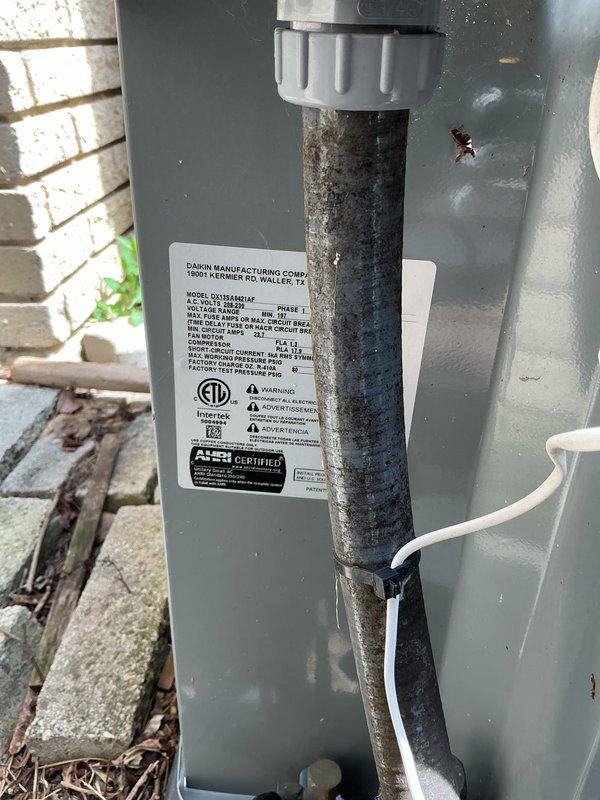 Completed comprehensive Gold AC inspection and tune-up on Daikin air conditioning system as part of plan membership benefits. Performed electrical diagnostics using digital multimeter to verify proper voltage and amperage readings at air handler unit, confirming system operating within manufacturer specifications at 4.12 measurement reading. Inspected indoor air handler cabinet, ductwork connections, and refrigerant line set for proper installation and integrity. Evaluated outdoor condensing unit including manufacturer label verification, electrical connections, and PVC condensate drain line routing. Noted outdoor unit showing age-appropriate weathering with minor surface oxidation on piping but structurally sound. All refrigerant hoses deployed for pressure testing and system performance verification. System operational and functioning properly with no immediate service needs identified. Annual maintenance completed per plan requirements.