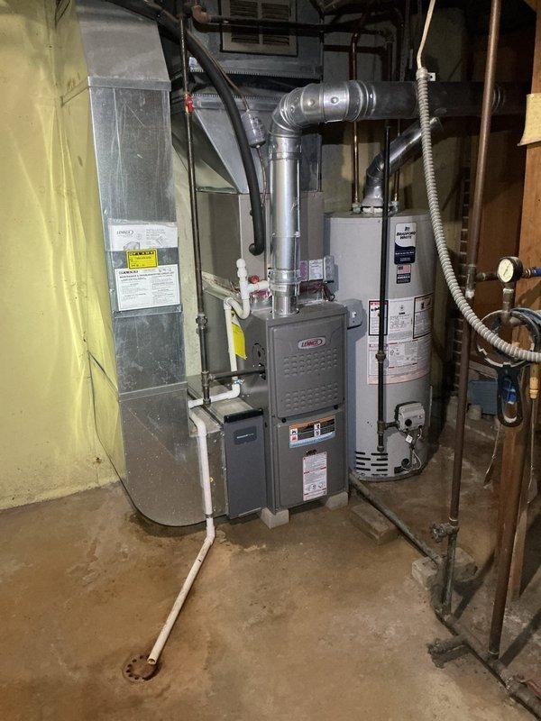 Responded to service call for non-operational Lennox furnace in basement mechanical room following water intrusion from recent plumbing leak. Performed complete system inspection of furnace, ductwork, and Emerson thermostat to assess water damage and verify operational status. Documented equipment condition with photographic evidence showing furnace, air handler, and associated components in utility room setting.