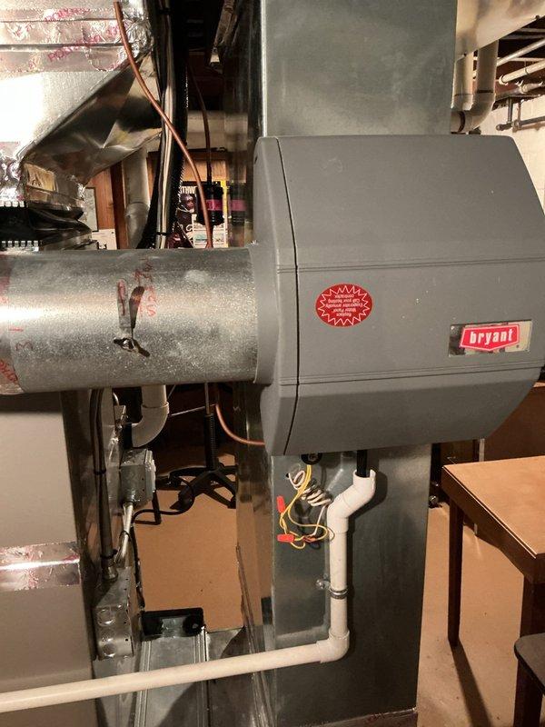 Completed comprehensive Gold AC inspection on 5-year-old residential air conditioning system. Verified operational status of both outdoor condensing unit and indoor air handler with Bryant humidifier component. Inspected electrical disconnect switch at exterior condenser location, confirmed proper positioning and functionality. Examined indoor equipment including ductwork connections, copper refrigerant lines, condensate drainage system, and electrical wiring. All components found operating within normal parameters with no immediate service needs identified. System cleared for continued operation.