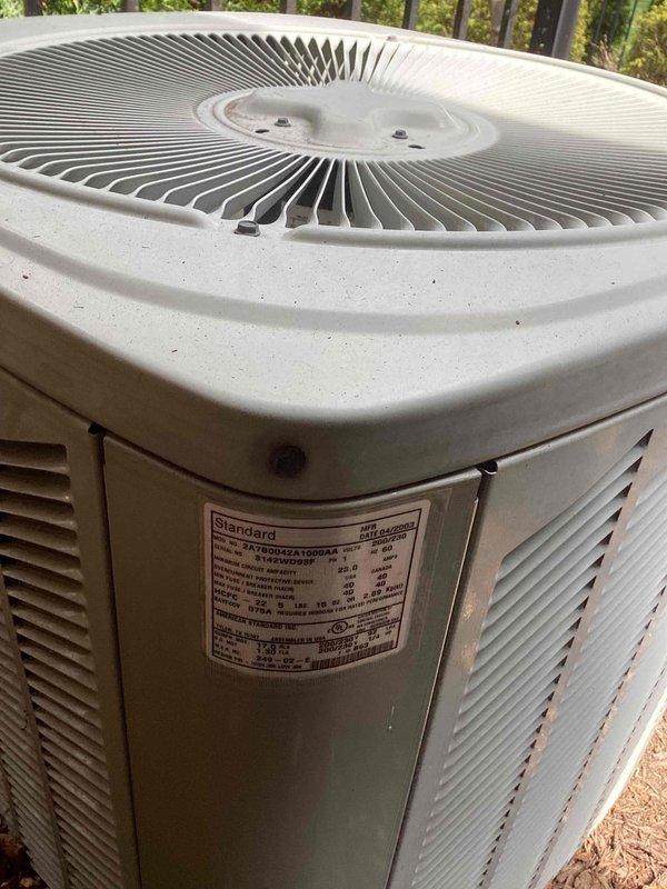 Completed Gold AC Inspection on a 10+ year old Standard brand air conditioning system with air handler located in basement. Performed comprehensive system evaluation including visual inspection of outdoor condenser unit and indoor components. Noted significant dust and debris accumulation on return air grille requiring cleaning to maintain proper airflow and system efficiency. Outdoor condenser unit showed normal weathering with operational fan assembly and intact manufacturer specifications label. System confirmed operational at time of inspection. Documented equipment condition with photographic evidence showing maintenance needs. Recommended filter replacement and vent cleaning to optimize system performance and indoor air quality.