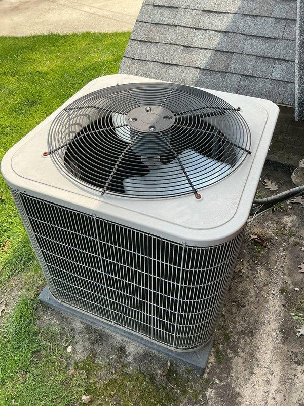 Completed comprehensive Gold AC inspection on single residential cooling system with air handler located on lower level. Performed thorough evaluation of outdoor condenser unit, which was found to be in functional condition with proper placement on concrete pad and adequate clearance from surrounding area. Inspected all exterior components including fan assembly, protective grilles, metal housing with vertical louvers, and refrigerant lines, confirming system operational status and documenting equipment condition through photographic records.