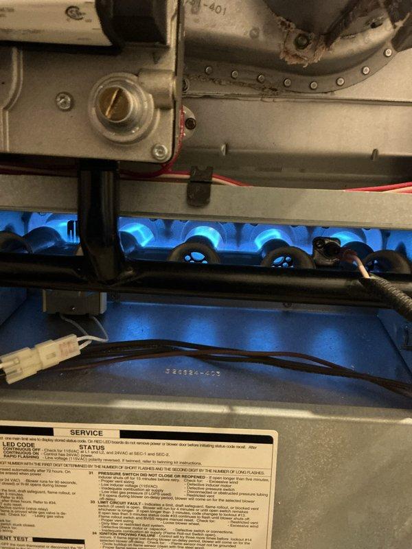 Completed comprehensive Gold furnace inspection on 24-year-old forced air heating system located in basement. Performed thorough examination of furnace components including burner assembly, heat exchanger, gas valve, ignition system, and blower motor. Verified proper burner flame characteristics with blue flame pattern indicating complete combustion and correct air-to-fuel ratio. Inspected electrical connections, control wiring, and safety devices. Examined ductwork connections and verified system operation. Unit is currently functioning properly with all components operating within normal parameters. Documented equipment model 3TCA-MU058-1100AJA with photos for service records. System passed inspection with no immediate repairs required at this time.