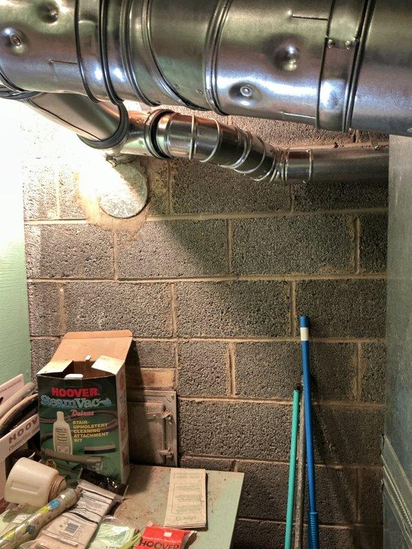 Responded to municipal inspection follow-up for recently completed HVAC installation. Inspector identified water heater venting with severe back pitch creating potential carbon monoxide hazard. Documented existing vent configuration with photographs showing horizontal ductwork runs and flexible connector sections in basement mechanical area. Venting requires correction to establish proper upward slope and ensure safe exhaust of combustion gases. Coordinated with management to schedule corrective work and eliminate CO risk.