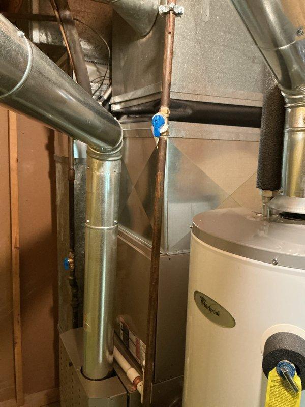 Conducted comprehensive evaluation of 10-15 year old HVAC system including air conditioning unit, furnace, and water heater located in basement. Assessed air conditioning unit with history of low refrigerant requiring recharge approximately five years prior, and inspected deteriorating black rubber insulation covering on refrigerant line set connecting outdoor condenser to indoor air handler. Provided replacement options for air conditioning unit only versus complete HVAC system replacement including both air conditioner and furnace, and evaluated water heater condition as part of overall mechanical system assessment.