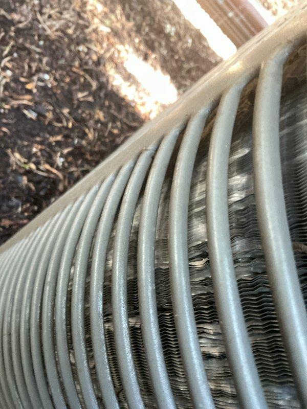Completed Gold AC Inspection on multi-unit residential system with equipment aged 3-5 years, including air handlers located in basement and second floor. Performed comprehensive visual inspection of outdoor condenser units, identifying significant debris accumulation and organic matter lodged between condenser coil fins, which restricts airflow and reduces heat transfer efficiency. Documented condition of refrigerant lines, electrical connections, and overall unit integrity through photographic evidence. Noted surface weathering and dirt accumulation on exterior casings consistent with normal outdoor exposure. All equipment operational at time of inspection, with condenser fan grilles and access panels intact and properly secured.